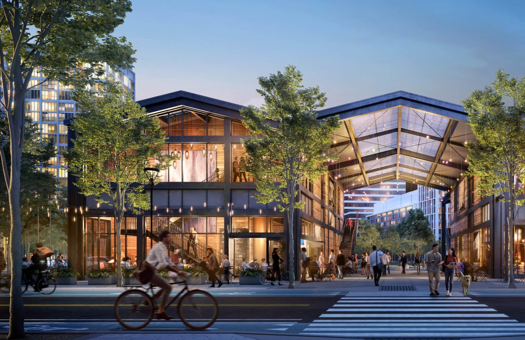 Evening view of lively urban retail pavilion with cyclists and pedestrians crossing illuminated street