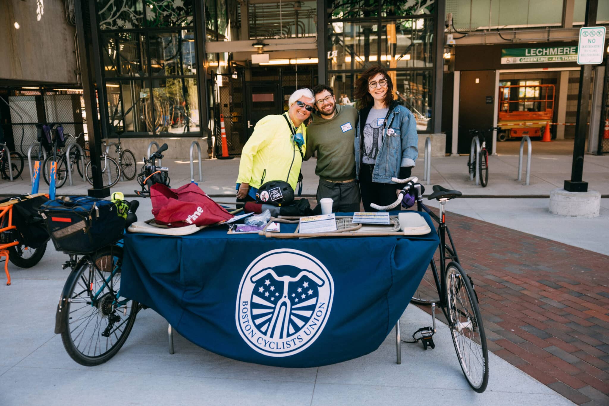 Bicycles parked behind informational table at vibrant Boston Cyclists Union outreach event