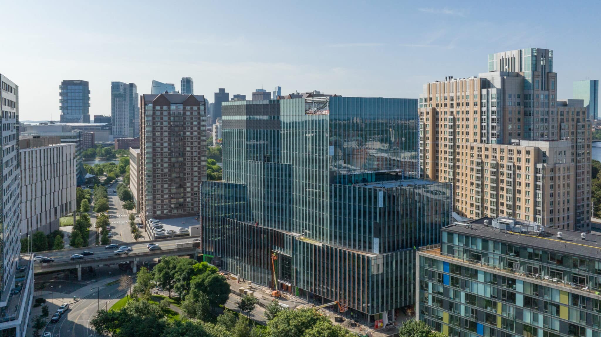 City skyline with large glass building surrounded by residential towers and overpass at Morgan Avenue