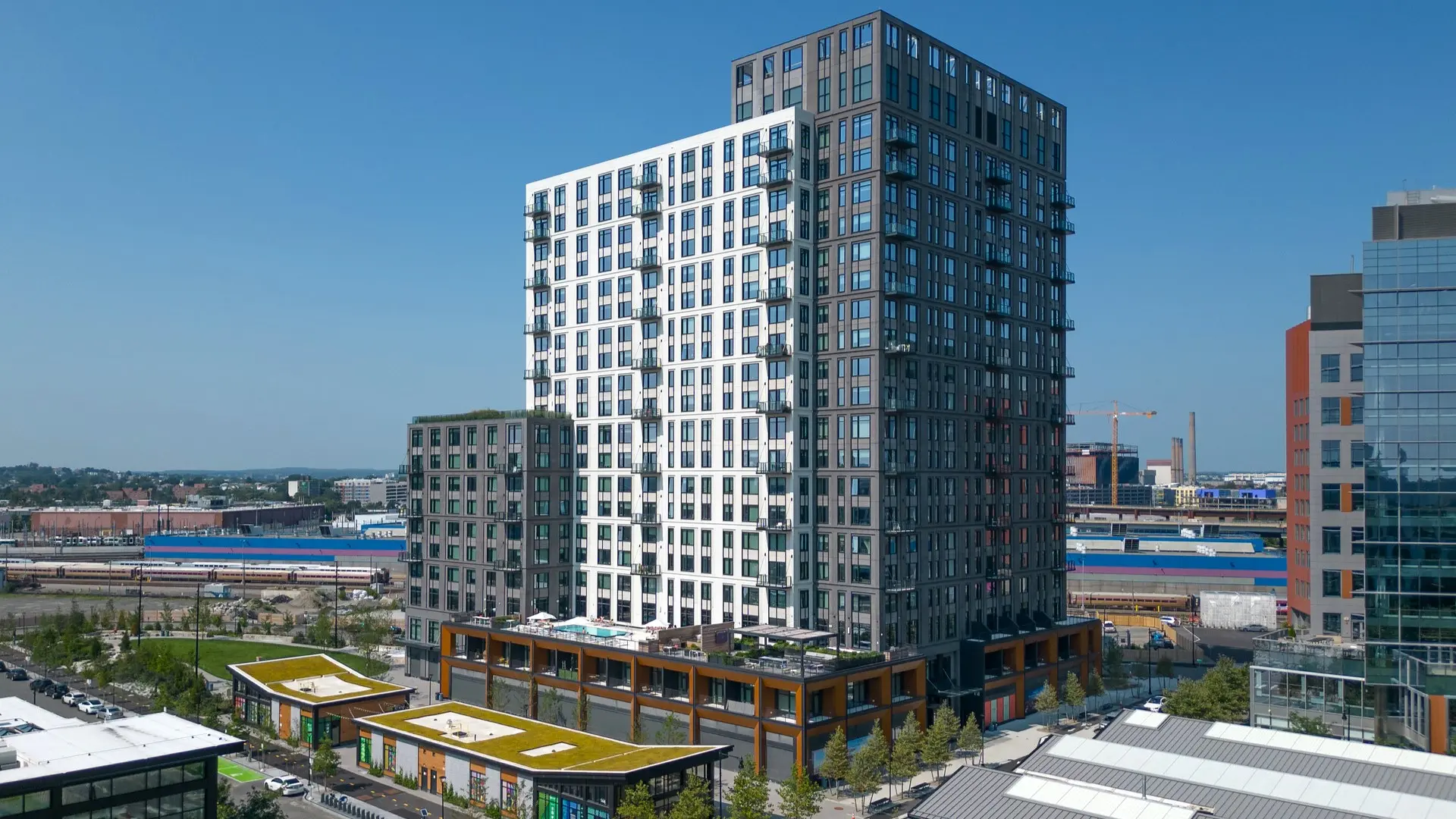 Contemporary high-rise building with rooftop pool and retail base dominates urban skyline