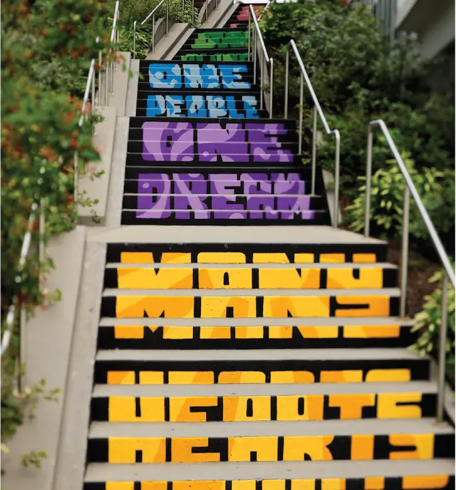 Painted stairs featuring bold text reading One People, One Dream in bright colors