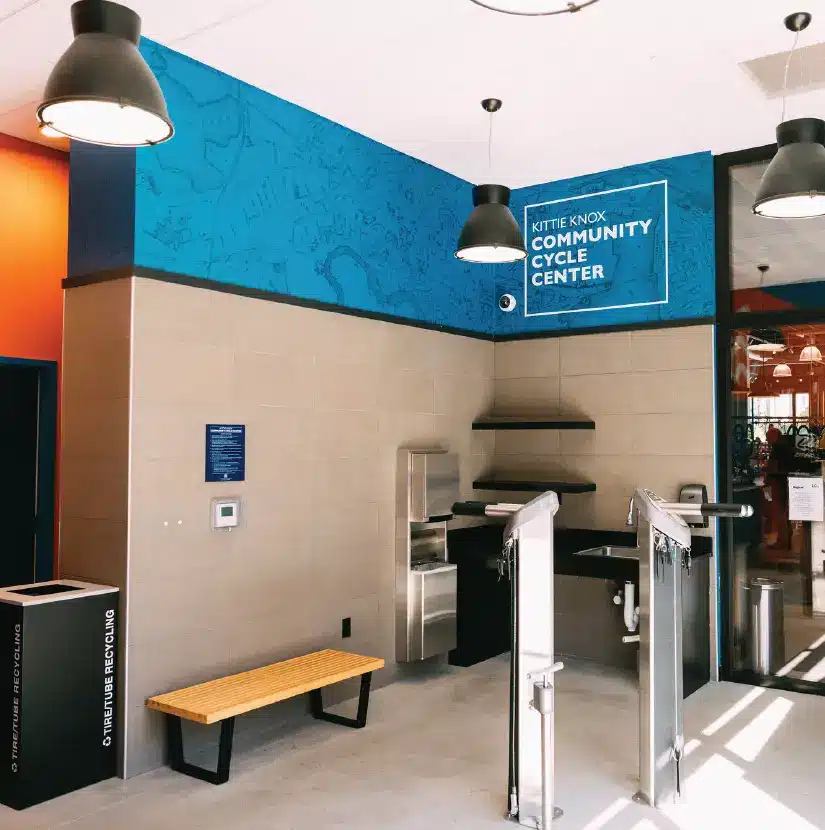 Interior of Kittie Knox Community Cycle Center with repair stations and blue city map wall mural