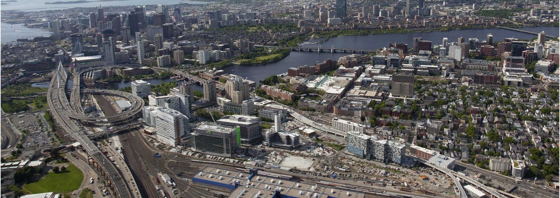 Aerial view of Boston showcasing major highways and downtown skyline near Charles River