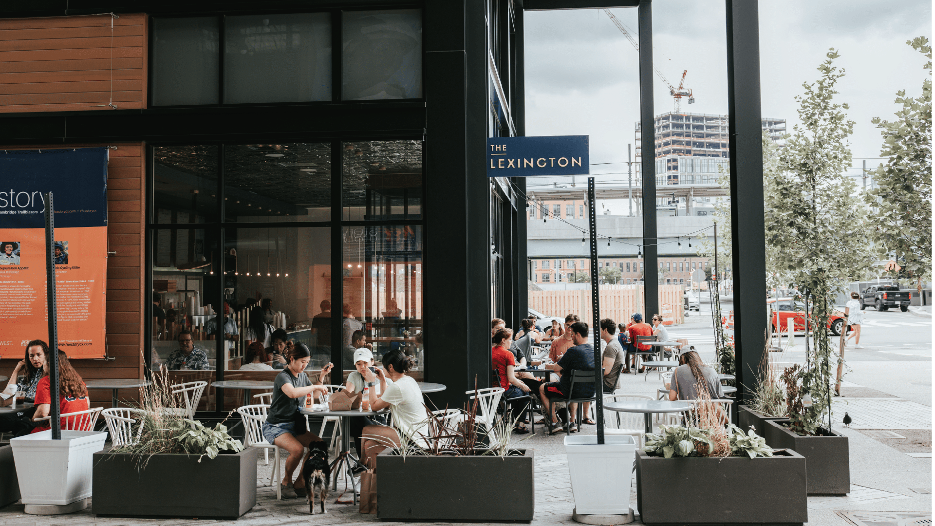 Outdoor dining area at The Lexington restaurant with people enjoying meals at shaded tables