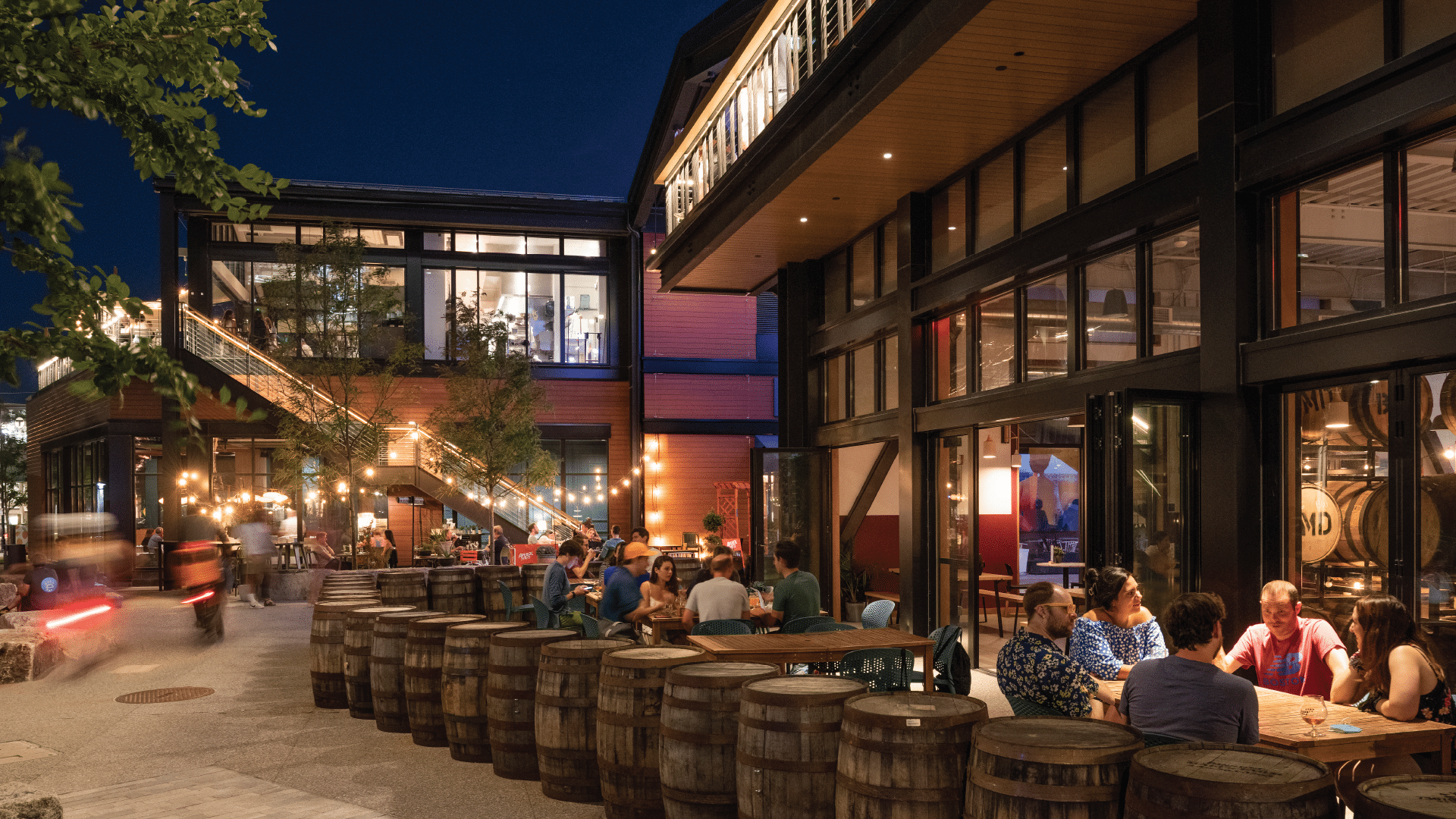 LampLighter Brewery: Groups enjoying drinks at outdoor brewery patio with string lights and wooden barrels